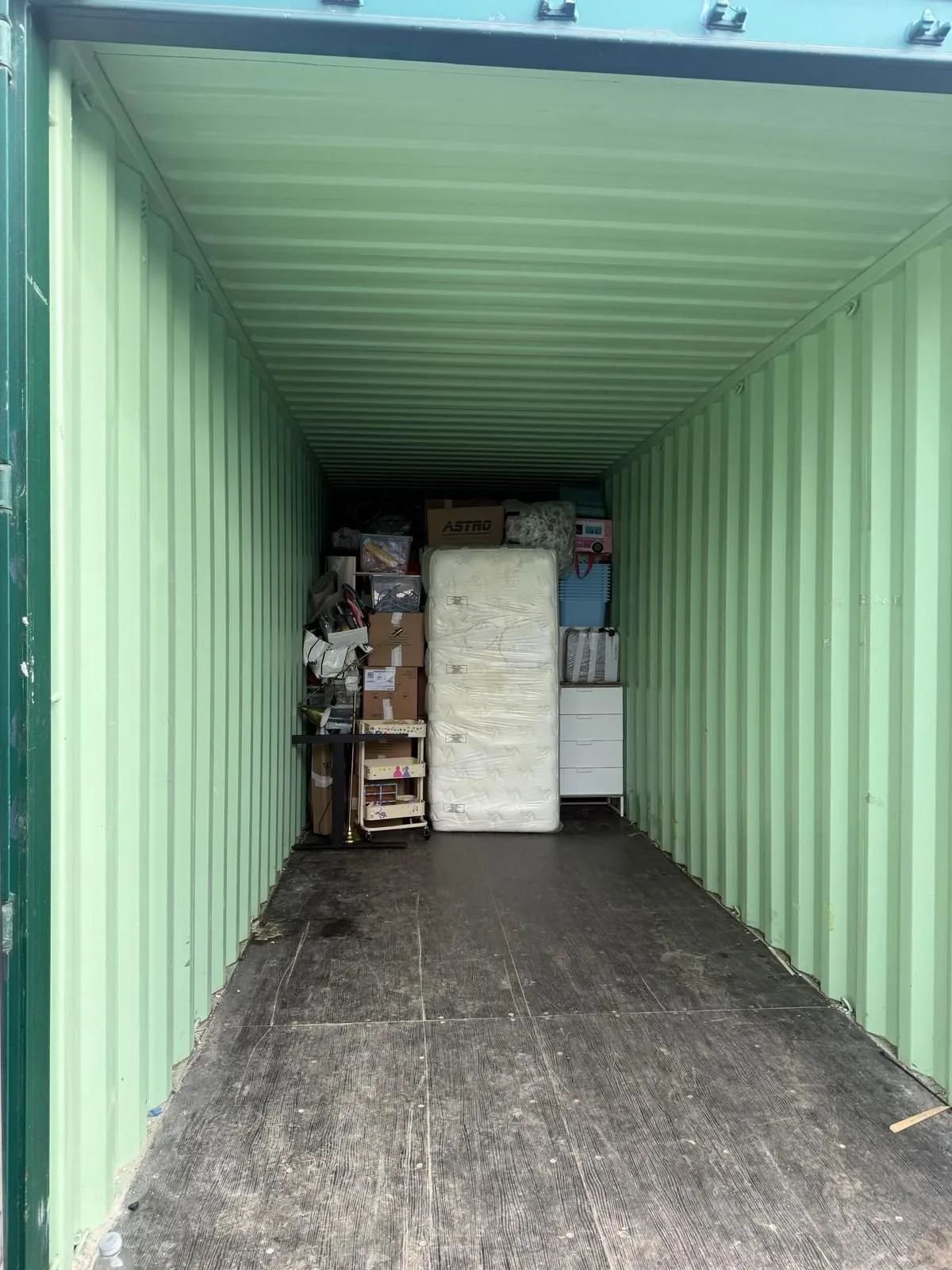 Reused cardboard boxes stacked beside wrapped furniture ready to load